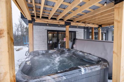 a hot tub in the back of a house at Nature Spa & Lake Access - Le Maikel in Beauceville-Est