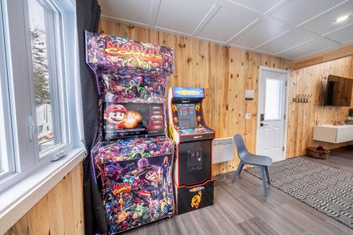a room with two video game machines next to a window at Nature Spa & Lake Access - Le Maikel in Beauceville-Est