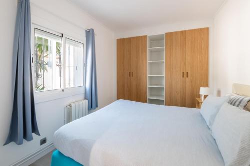 a bedroom with a white bed and a window at Sitges Blue - completamente reformado en 2025 in Sitges