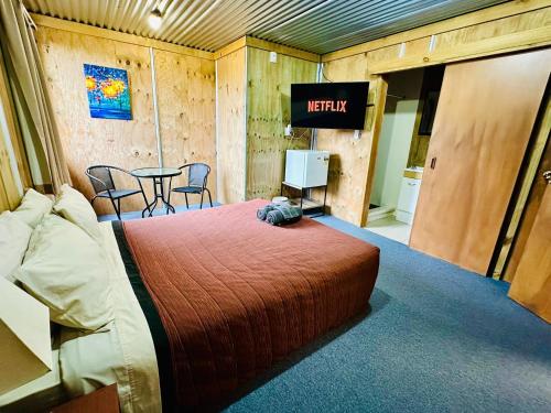a hotel room with a bed and a television at The Crossing Lodge & Backpackers in National Park