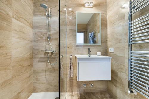 a bathroom with a shower and a sink and a mirror at Bouganvilla House in Ariany