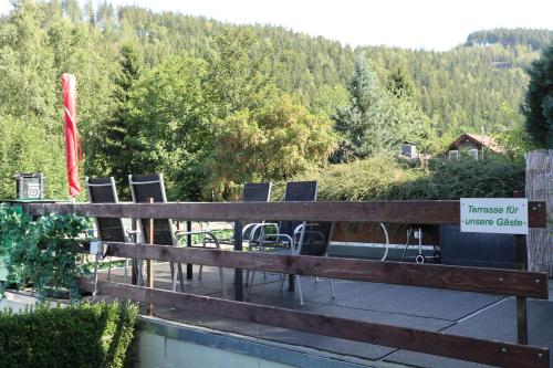a deck with chairs and a sign on it at Birkenstübchen in Lautenthal