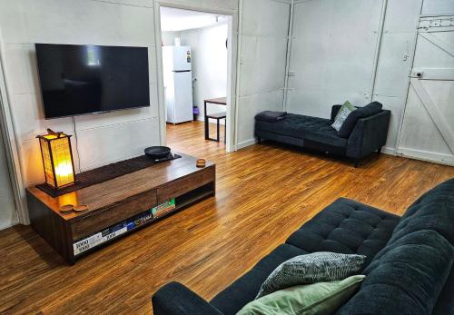 a living room with a couch and a tv at Lady Bay Beach House - seconds from the sand in Normanville