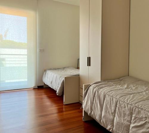 a bedroom with two beds and a window at Roseto Marina Lungomare in Roseto degli Abruzzi