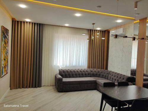 a living room with a couch and a table at DREAM HOUSE TASHKENT Airtport in Stantsiya Kyzyl-Tukumachi