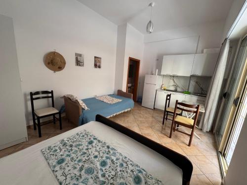 a bedroom with a bed and a table and a kitchen at Mira Orikum in Orikum