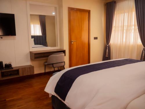 a hotel room with a bed and a mirror at Captain Residency in Lagos