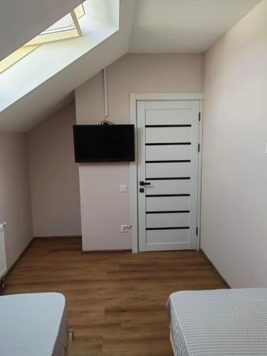 a attic room with two beds and a door at Like Hostel in Chişinău