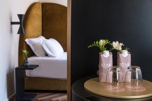 a table with two bottles and a table with a bed at Palazzo Buenos Aires in Milan