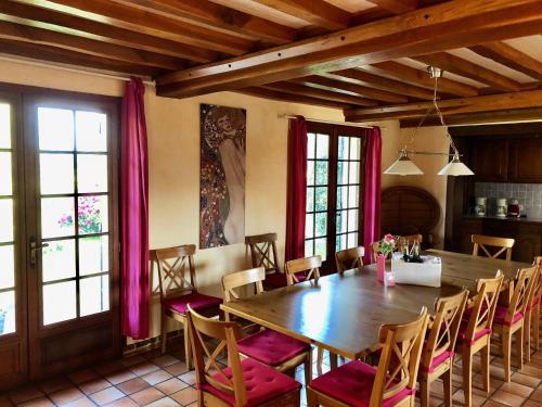 a dining room with a wooden table and chairs at Villa Les hortensias RDC in Maniquerville