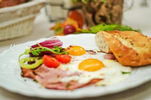 a plate of food with eggs and bread and salad at Golden Royal Boutique Hotel & Spa in Košice