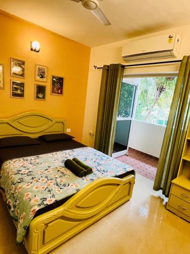 a bedroom with a bed with a yellow wall at Namaste at Beachside 2BHK, with Free Breakfast in Varca