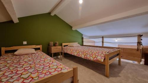 1 Schlafzimmer mit 2 Betten und einer grünen Wand in der Unterkunft Cocon au cœur des Montagnes in Puyvalador