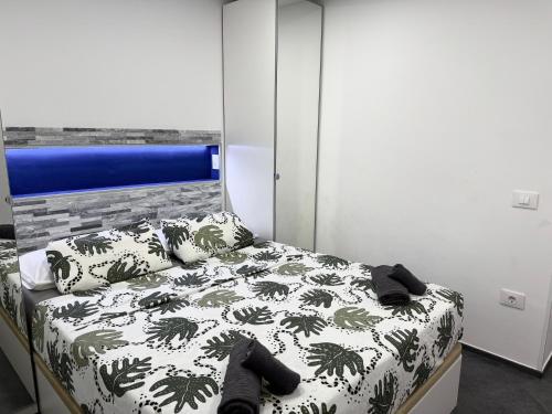 a bedroom with a bed with a black and white comforter at Wonderful stay in Tenerife Royal Gardens Resort! in Playa de las Americas