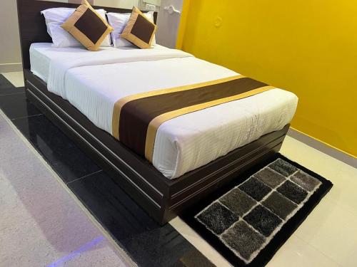 a bedroom with a bed with white sheets and pillows at Hotel Infinity in Rājgīr