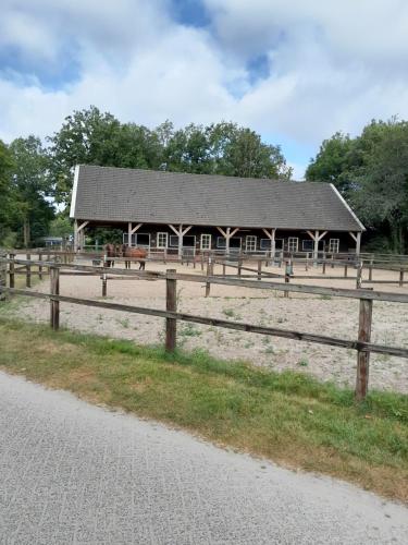 a barn with a wooden fence in front of it at 6 persoons stacaravan Drenthe in Hoogersmilde