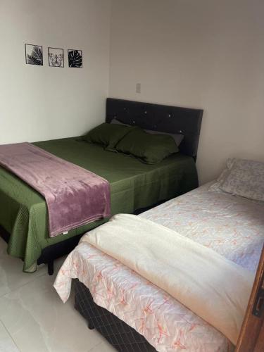 Cette chambre comprend 2 lits et 2 jupes de lit. dans l'établissement Casa Privativa com Quarto Confortável e Cozinha Ótima Localização em Foz do Iguaçu, à Foz do Iguaçu