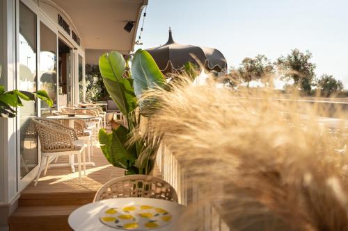 a balcony with tables and chairs and plants at Park Hotel Pineta Boutique Hotel in Caorle