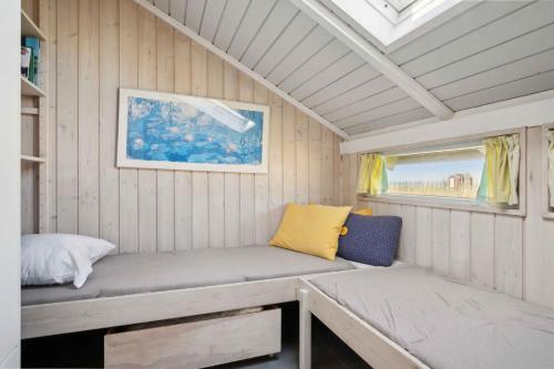 Nørre ÅbyにあるCozy Summer House In Føns With Sea Viewのベンチと窓付きの小さな客室です。