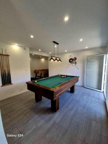 Una sala de estar con una mesa de billar. en Chalet familial 6 chambres 250m2, en Le Dévoluy