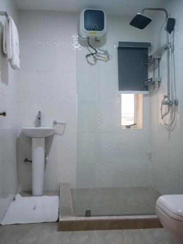 a bathroom with a shower and a sink and a toilet at Captain Residency in Lagos