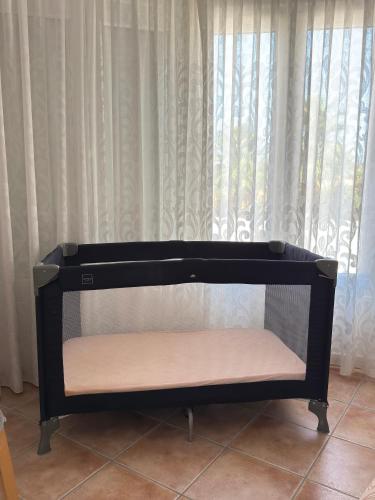 a black shelf in front of a window with curtains at Villa Arizona in Catral