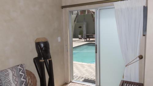 a sliding glass door leading to a swimming pool at Sunset Lodge & Safaris in Guernsey Nature Reserve