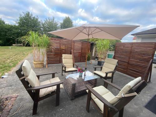 a patio with chairs and a table with an umbrella at Ferienhaus im Grünen in Bad Hersfeld