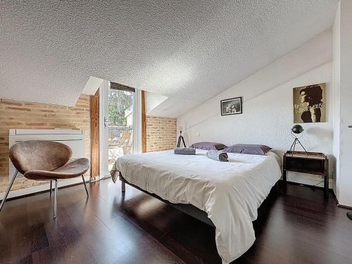 una camera da letto con un letto grande e una sedia di Superbe LOFT centre-ville - Sauna - parking privé -Clim- 1 à 10personnes a Brive-la-Gaillarde