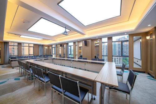 張家界市にあるFriend Zhangjiajie Hotel-Free pick-upの長いテーブルと椅子のある大きな会議室