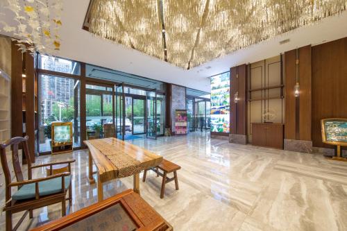 張家界市にあるFriend Zhangjiajie Hotel-Free pick-upのテーブルと椅子のある建物のロビー