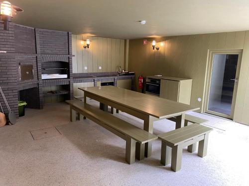 a kitchen with a wooden table and two benches at Casa da Fonte de Cima in Celorico de Basto