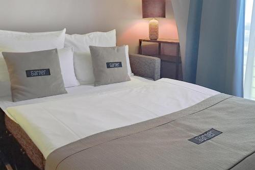 a bed in a hotel room with two pillows at Garner Hotel Elmshorn by IHG in Elmshorn