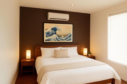 a bedroom with a bed and a painting of a wave at Zen on the River Lux 3BR with Japanese Deep Bath Walk to Down Town in Margaret River Town