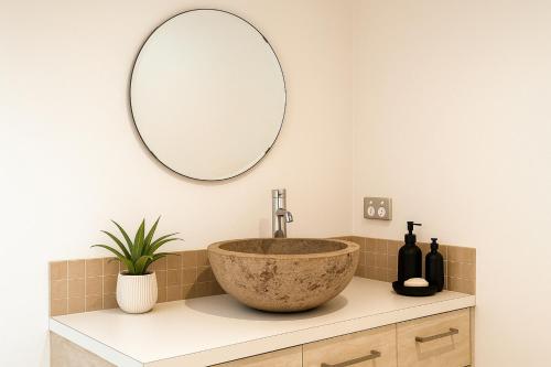 a bathroom with a bowl sink and a mirror at Zen on the River Lux 3BR with Japanese Deep Bath Walk to Down Town in Margaret River Town