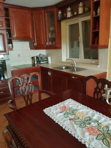 a kitchen with a wooden table with a table cloth on it at Apartments M&E in Mokošica