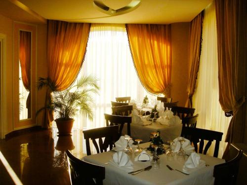 a restaurant with white tables and chairs and a large window at Hotel Imperial Timisoara by JR in Timişoara