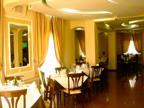 a dining room with tables and chairs and a mirror at Hotel Imperial Timisoara by JR in Timişoara