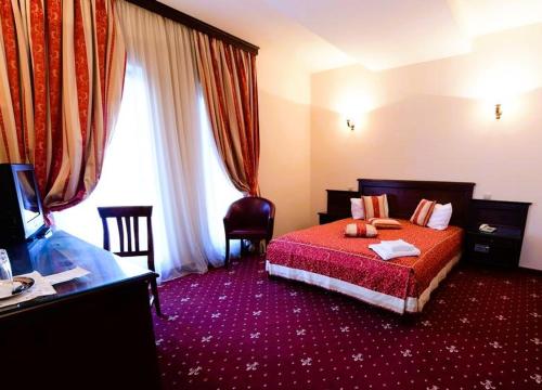 a hotel room with a bed and a television at Hotel Imperial Timisoara by JR in Timişoara