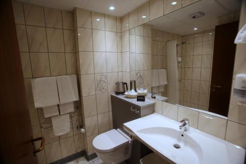 a bathroom with a sink and a toilet and a mirror at Taastrup Park Hotel in Tåstrup