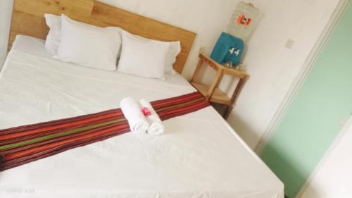 a bedroom with a bed with two towels on it at Twins Homestay ekas in Pulau Gilkaliantan