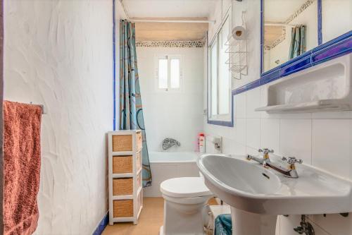 a white bathroom with a sink and a toilet at Rustico C in Tarifa
