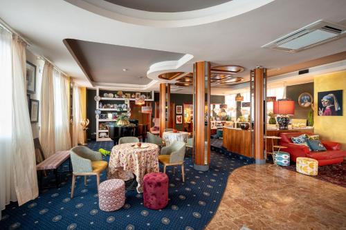 a living room with a table and chairs at Park Hotel Pineta Boutique Hotel in Caorle