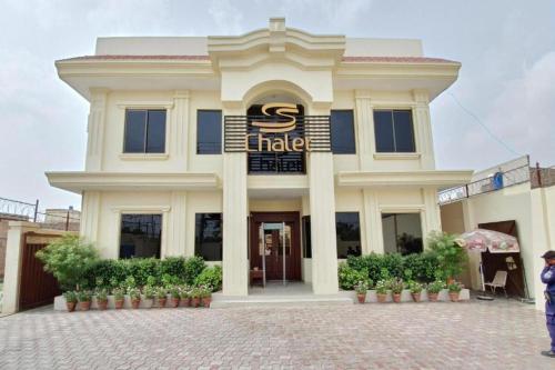 a large white building with a sign on it at Mina Hotel in Dargai