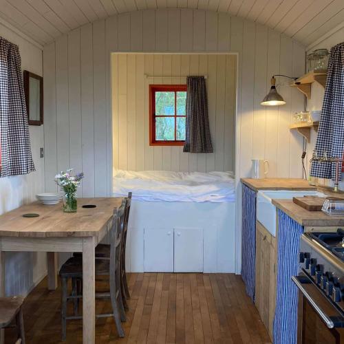 a kitchen with a table and a window in a room at Secluded off grid Shepherd's Hut in Minchinhampton