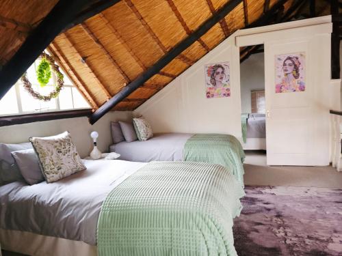 a bedroom with two beds in a attic at Bergvliet Cottages - Salvado and Esparanza in Clarens