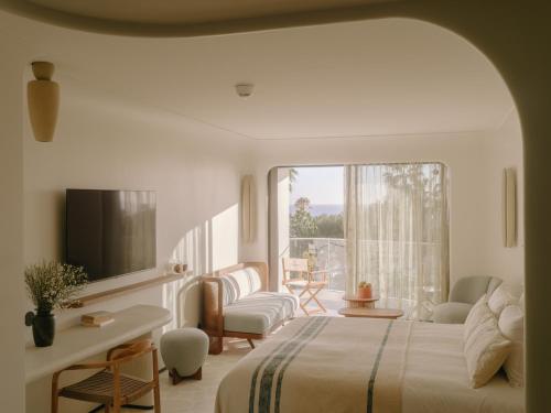 a bedroom with a bed and a room with a window at Hôtel & Spa Belle Plage in Cannes