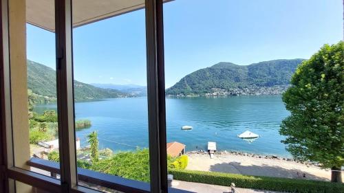a view of a lake from a window at La veranda sul lago - spiaggia privata e vista lago in Porto Ceresio