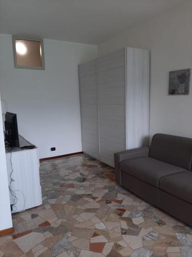 a living room with a couch and a tiled floor at La veranda sul lago - spiaggia privata e vista lago in Porto Ceresio