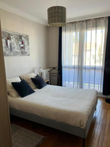 a bedroom with a large bed with blue pillows at Le Relais des Cyclamens Bron in Bron